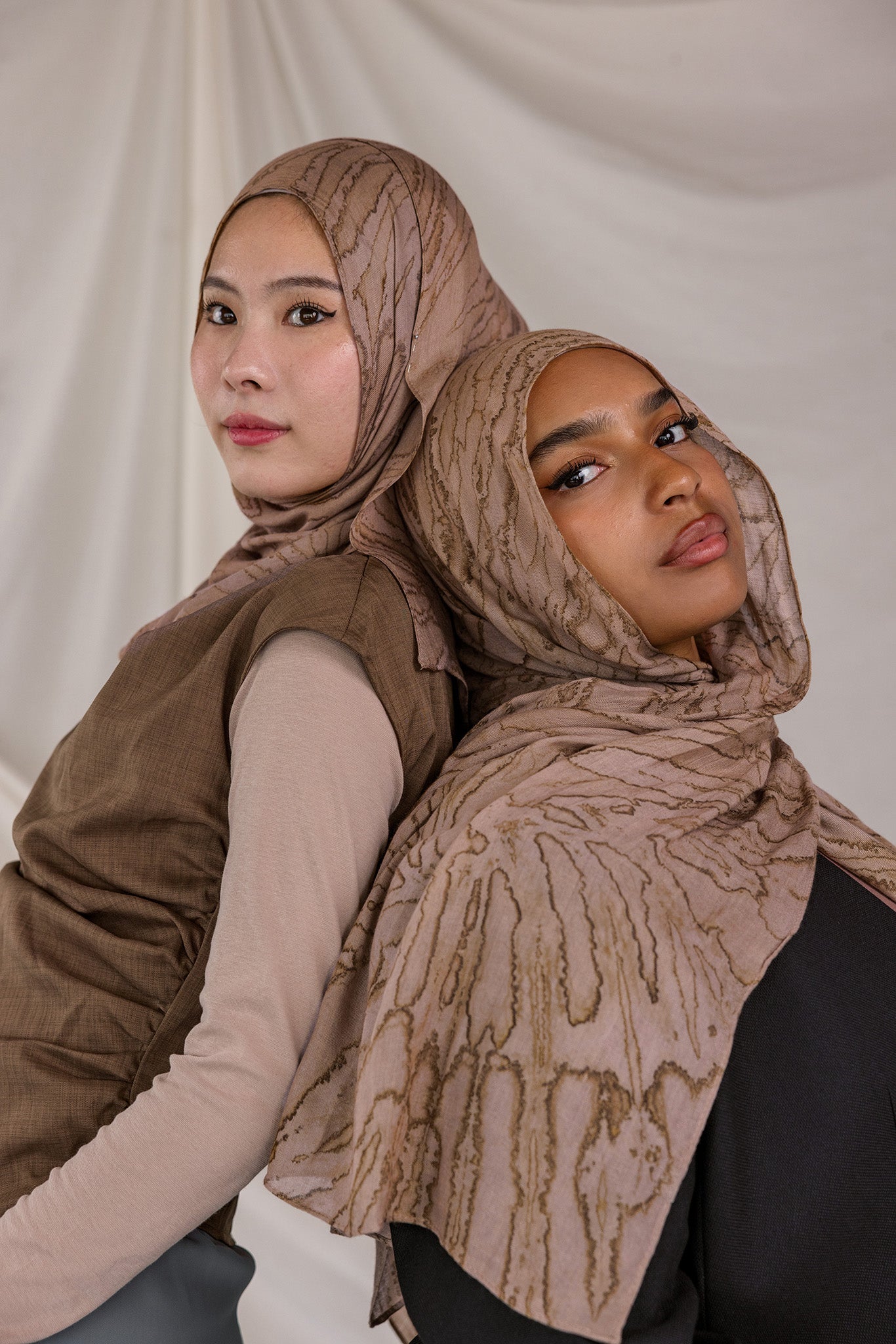 Two models styled in Mocha Dunes patterned hijabs against a plain background.