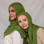 Model in Fern Green stands beside another model in Fern Green styled differently. 
