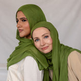 Model in Fern Green stands beside another model in Fern Green styled differently. 