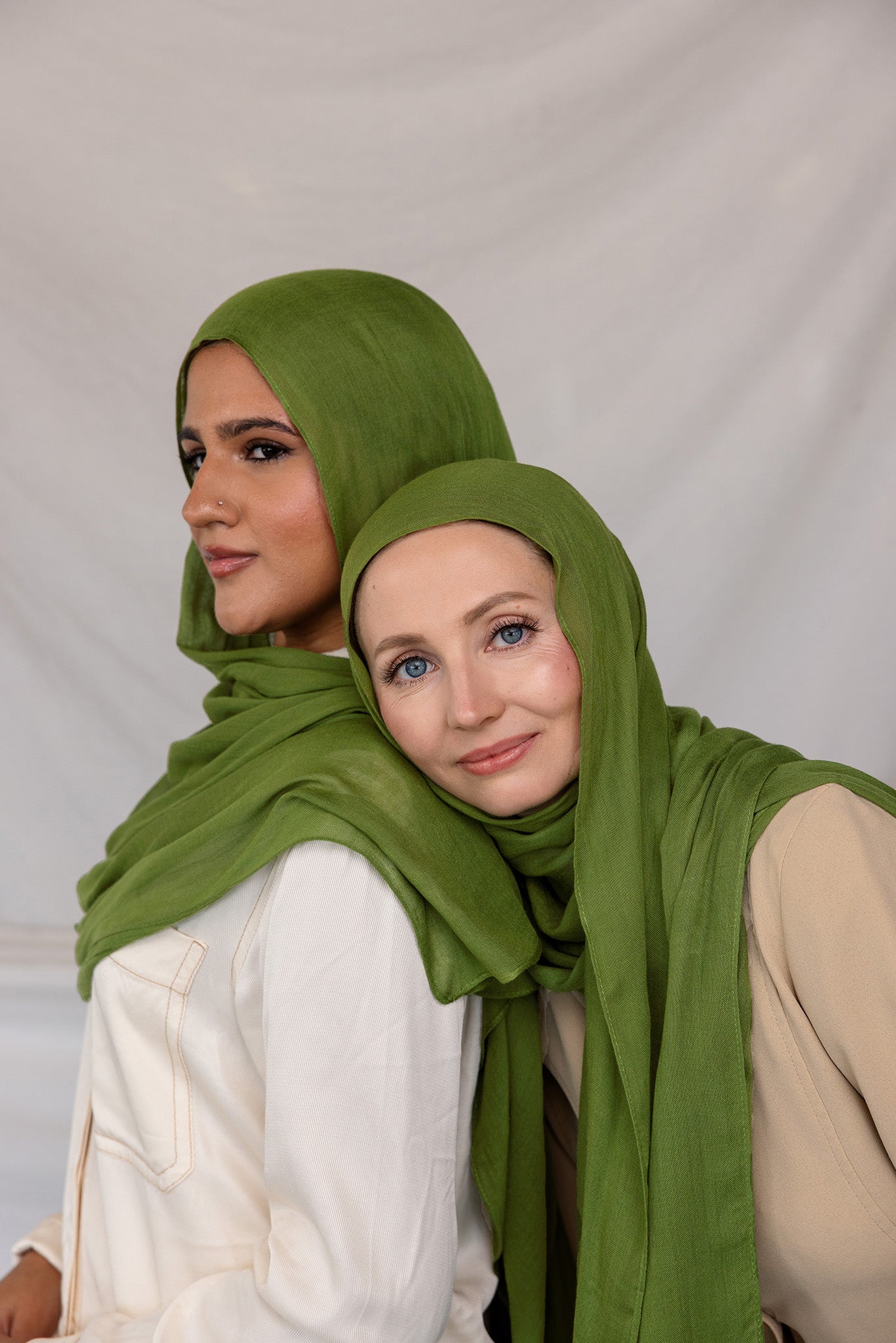 Model in Fern Green stands beside another model in Fern Green styled differently. 