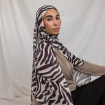 Model shown wearing VELA's Zebra print, which features deep berry toned stripes like a zebra, on a white base. 