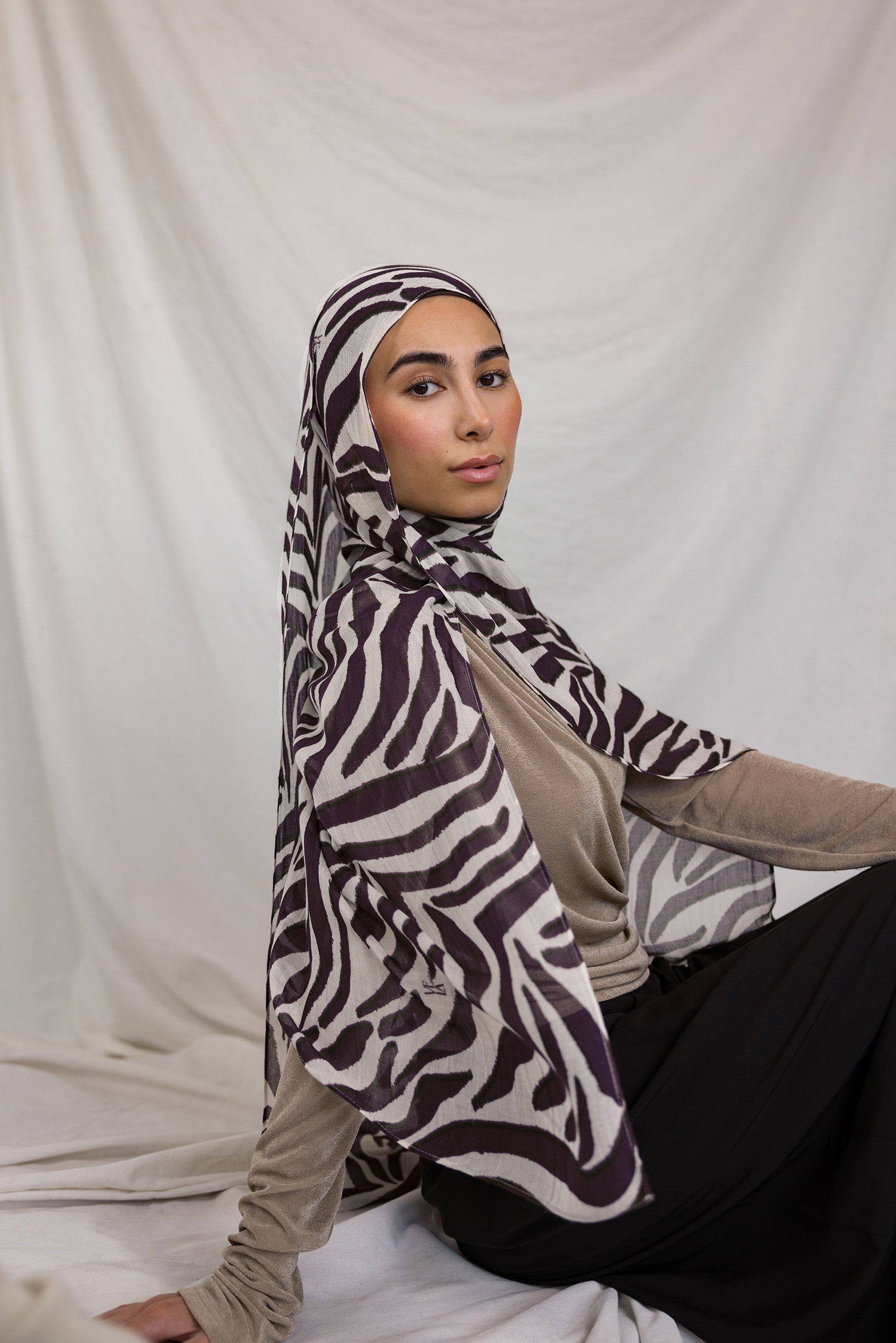 Model shown wearing VELA's Zebra print, which features deep berry toned stripes like a zebra, on a white base. 