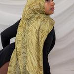 Woman wearing a olive printed dune hijab against a white background