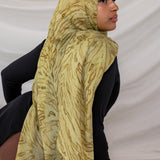 Woman wearing a olive printed dune hijab against a white background