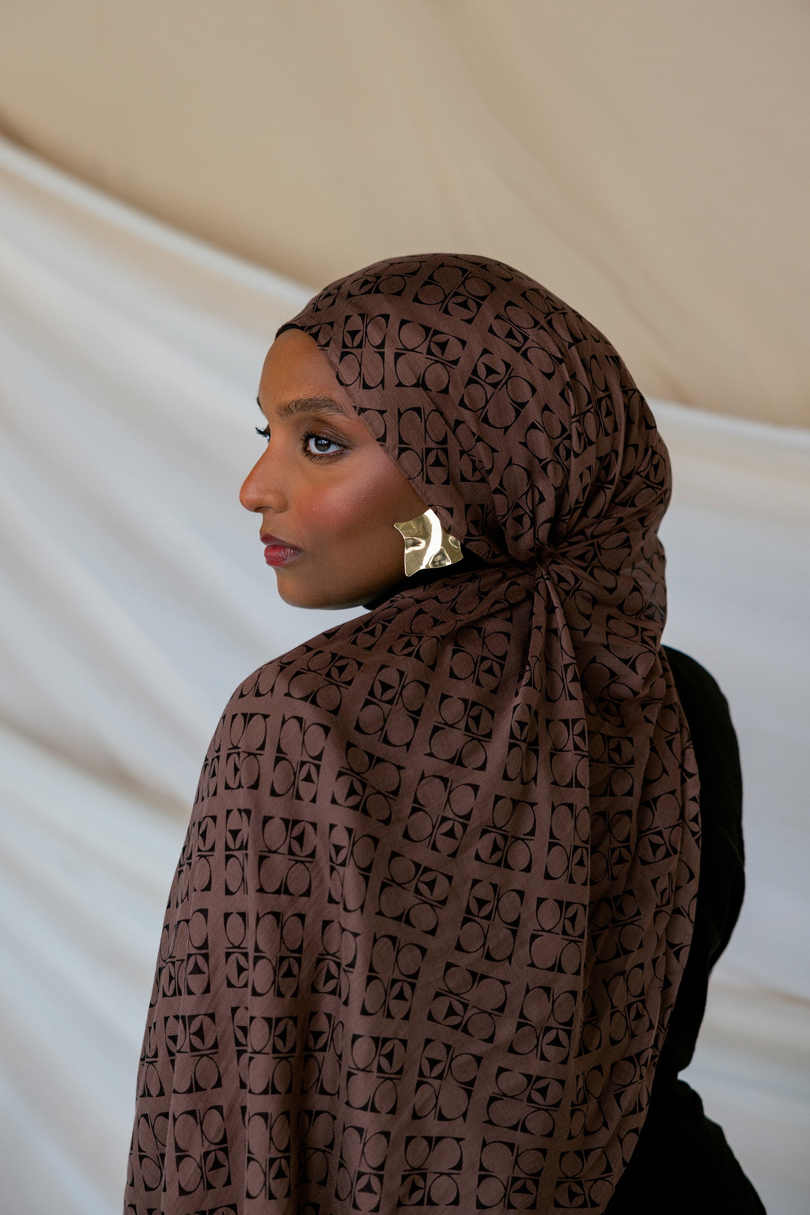Model wearing brown Art Deco styled print hijab. 