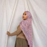 Image of model posing in pink and purple snakeskin scarf showing long draping ability of fabric. 