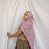 Image of model posing in pink and purple snakeskin scarf showing long draping ability of fabric. 