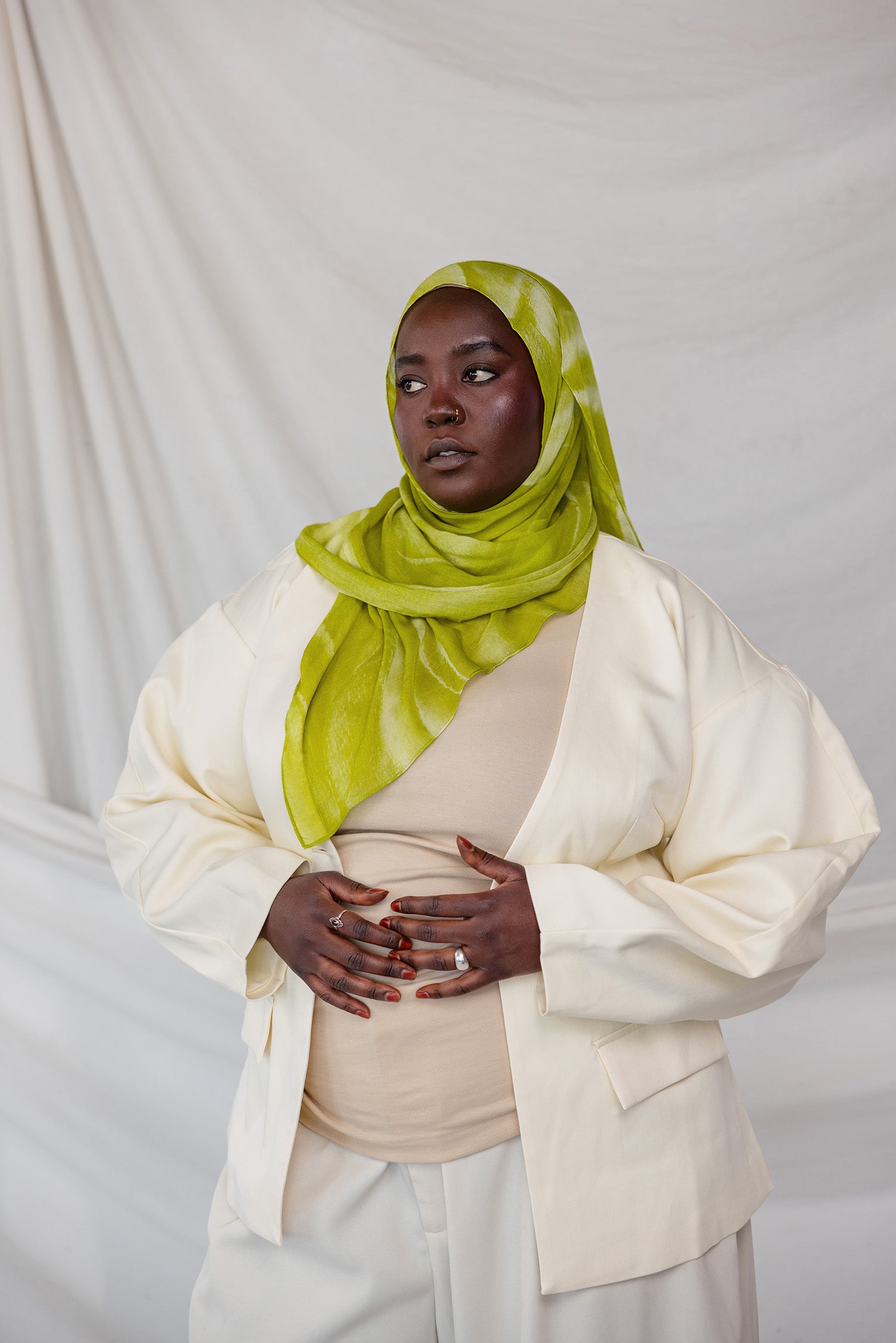 Model styled in a lime green sediment printed hijab and white outfit against a plain background
