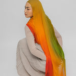 Person wearing a mango hijab with an ombre effect on a plain background