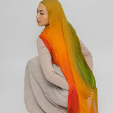 Person wearing a mango hijab with an ombre effect on a plain background
