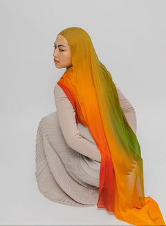 Person wearing a mango hijab with an ombre effect on a plain background