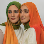Two women wearing mango ombre hijabs against a plain background