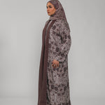 Woman wearing a floral abaya and hijab on a gray background