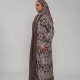 Woman wearing a floral abaya and hijab on a gray background
