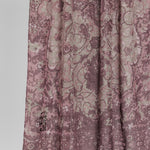 Close-up of hijab fabric with a mauve floral pattern on a white background