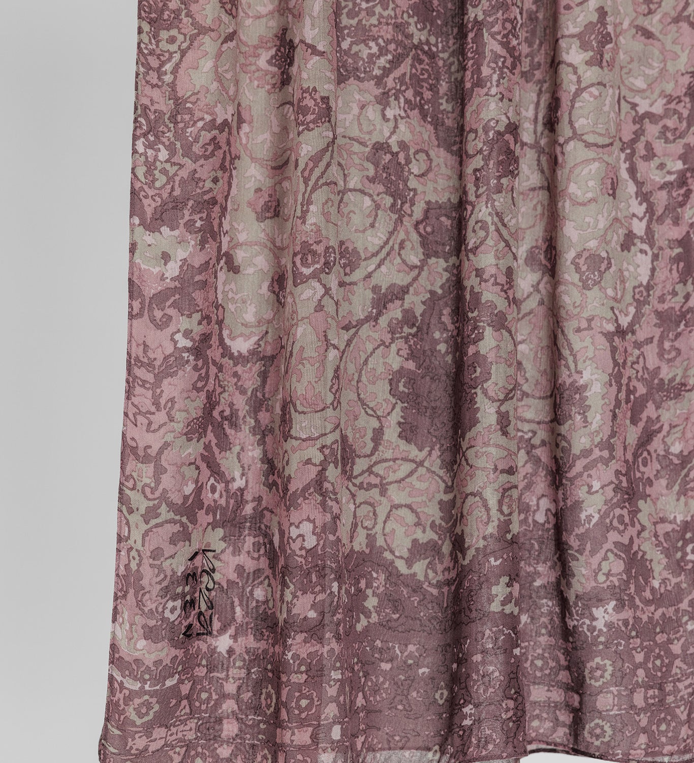 Close-up of hijab fabric with a mauve floral pattern on a white background