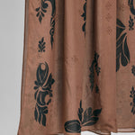 Brown hijab fabric with black floral patterns on a white background