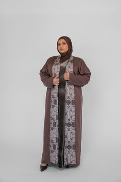 Woman wearing a brown abaya with a hijab on a white background