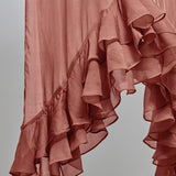 A close-up of a nectar pink ruffled fabric, showing the layered, cascading texture of the material against a neutral gray background.