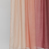 Hijab fabric swatch with gradient color from light pink to red on a plain background