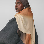 Woman wearing a ombre gradient hijab with a plain background