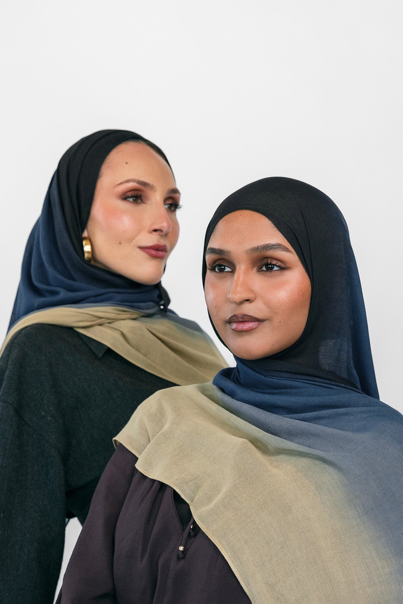 Two women wearing blue ombre hijabs with a neutral background