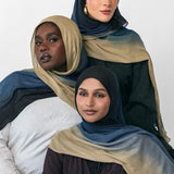 Three women wearing blue ombre hijabs in various colors on a white background