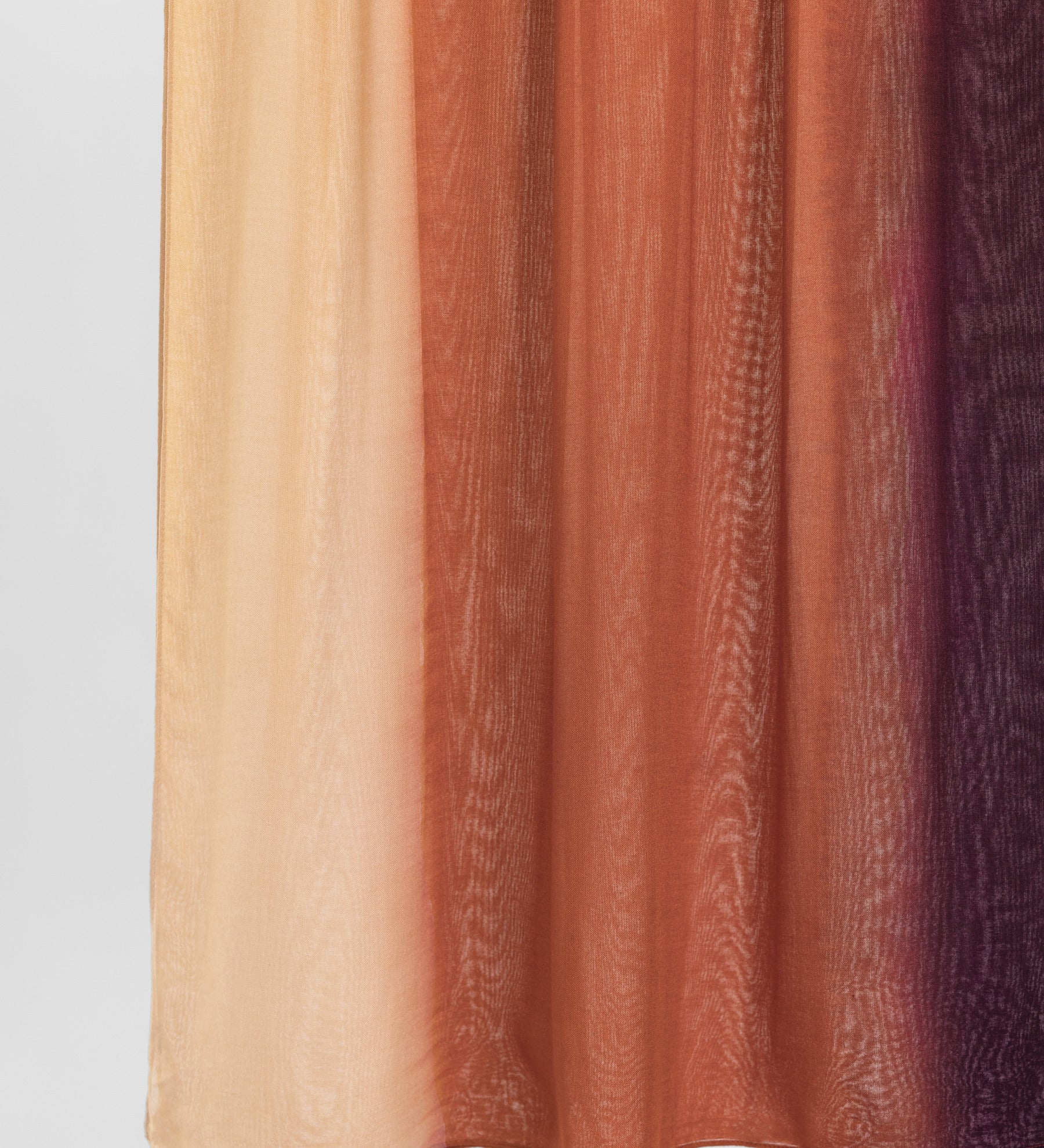 Ombre fabric swatch with colors transitioning from beige to brown to purple on a light gray background.