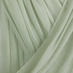 Close-up of light pastel green hijab with folded draping against backdrop