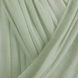 Close-up of light pastel green hijab with folded draping against backdrop