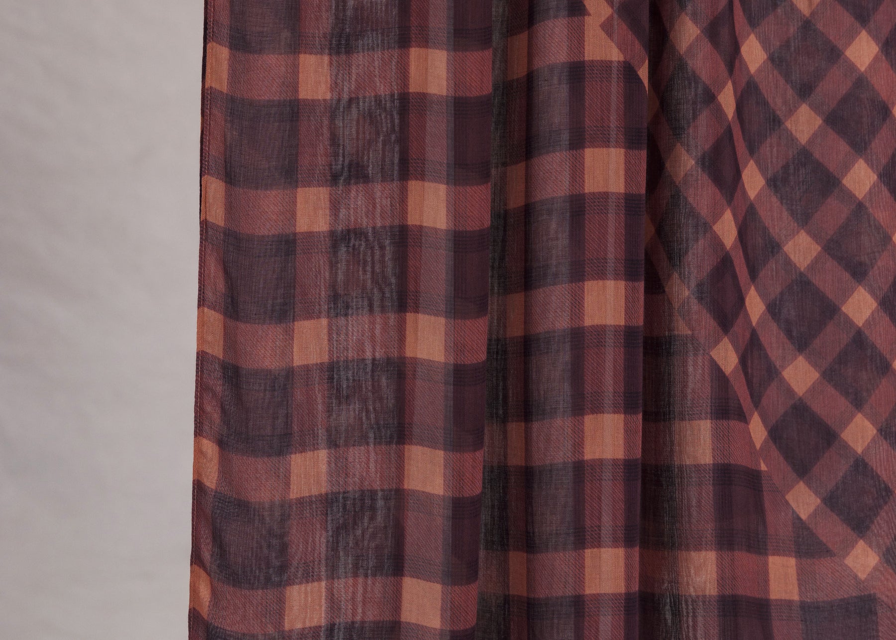 Plaid fabric with brown and red pattern on a neutral background