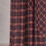 Plaid fabric with brown and red pattern on a neutral background