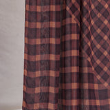 Plaid fabric with brown and red pattern on a neutral background