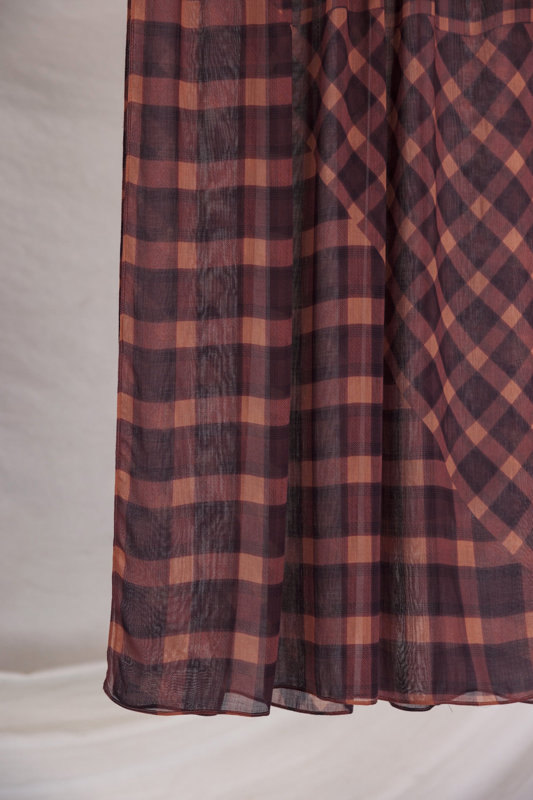 Plaid fabric with brown and red pattern on a neutral background