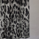 Black and white leopard print fabric with a plain background