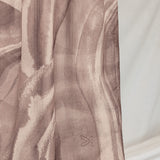Sediment pattern on brown hijab against a white background