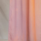 Pink, orange, purple gradient hijab draped in front of a neutral background