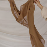 Brown fabric being held against a neutral background