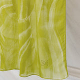 Lime green sediment print hijab draped in front a white background