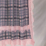 Plaid fabric with pink lace trim on a gray background