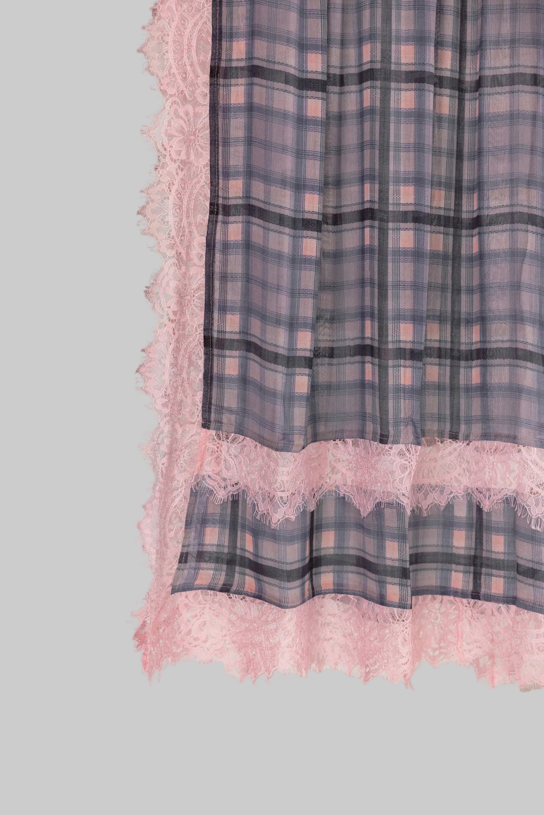 Plaid fabric with pink lace trim on a gray background