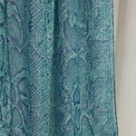 A close-up product shot of the Aqua Cobra scarf that features blue and teal scale-like designs.