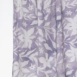 A close-up of a lavender and white floral patterned fabric, likely a scarf or lightweight wrap, shown hanging against a plain white background.