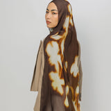Woman wearing a brown and beige patterned hijab on a white background