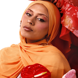 Two women wearing colorful headscarves with flowers in their hands on a white background