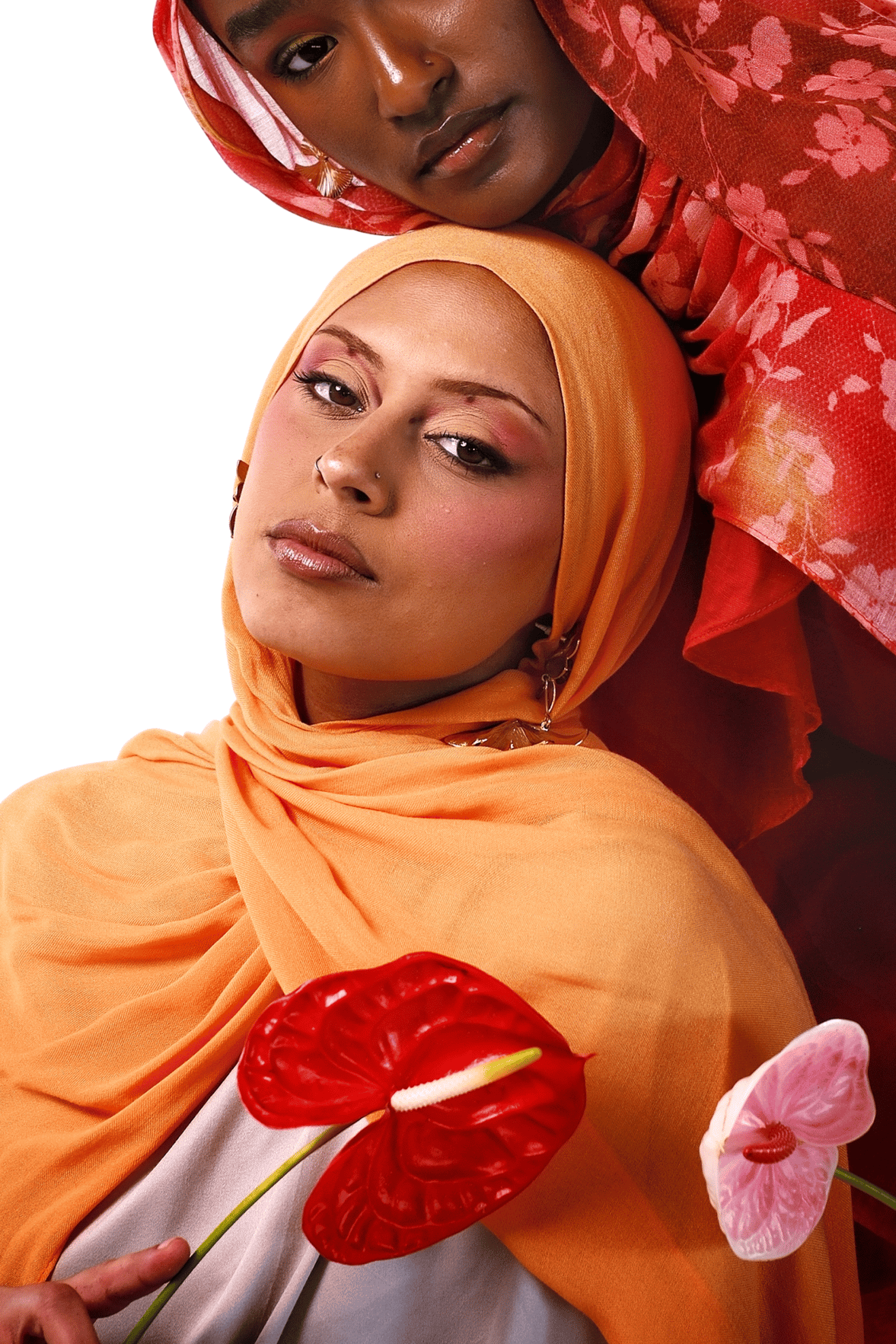 Two women wearing colorful headscarves with flowers in their hands on a white background
