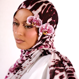 Woman wearing a patterned hijab with pink flowers on a white background