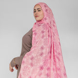 Woman wearing a pink floral hijab on a white background