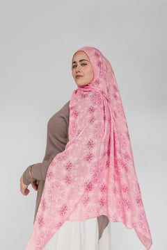 Woman wearing a pink floral hijab on a white background