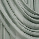 A close-up of draped sage green sheer curtains with soft folds and a light neutral background visible in the gaps.